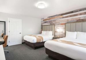 a hotel room with two beds and a desk at Quality Inn South Lake Tahoe in South Lake Tahoe
