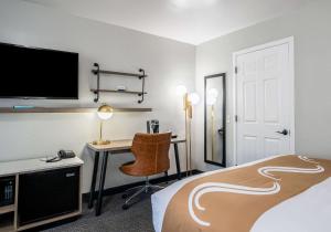 a hotel room with a bed and a desk with a television at Quality Inn South Lake Tahoe in South Lake Tahoe +37 photos