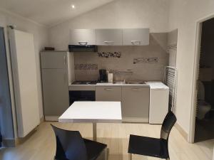 a small kitchen with a table and a chair at Motel D'ornex in Ornex