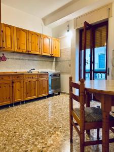a kitchen with wooden cabinets and a table and a stove at Sea View Apartment in Gallipoli