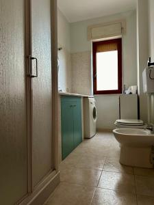 a bathroom with a sink and a toilet and a window at Sea View Apartment in Gallipoli +16 photos