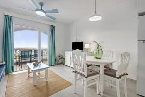 uma sala de estar com uma mesa e cadeiras e uma janela em Apartamento 103 Castell Sol em Arenal d'en Castell