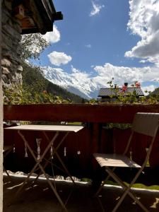 d'une table et de chaises sur un balcon avec une montagne enneigée. dans l'établissement Appartement Chamonix, à Chamonix-Mont-Blanc
