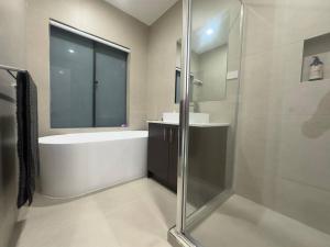 a bathroom with a shower and a tub and a sink at Stockmans in Truganina +14 photos