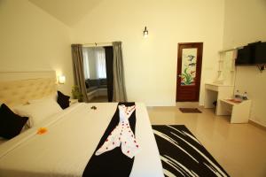 a bedroom with a bed with a tie on it at Olive Periyar in Thekkady