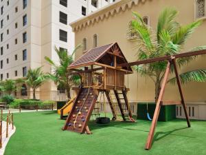 a playground with a slide and a play structure at Mövenpick Hotel Jumeirah Beach in Dubai