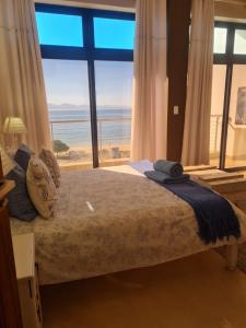 a bedroom with a bed with a view of the ocean at Point Village Accommodation - Santos 61/62 in Mossel Bay