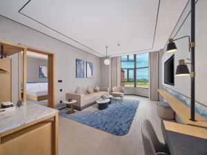 HuludaoにあるHilton Garden Inn Huludao Longxing Roadのリビングルーム(ソファ、ベッド付)、リビングルーム