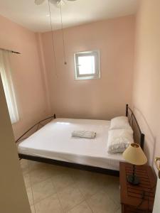 una cama en una habitación con ventana en Ilisia Neapoli apartments 2, en Neápolis