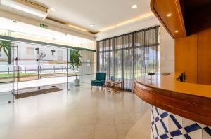 una hall con una scrivania e una sedia verde di TURIM Algarve Mor Apartamentos Turísticos a Portimão