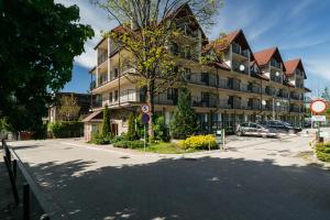 Un gran edificio con coches aparcados delante. en Brzozova Apartments Zakopane - LoftAffair, en Zakopane