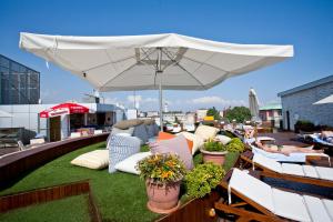 a patio with a white umbrella and chairs on a roof at Klas Hotel in Istanbul