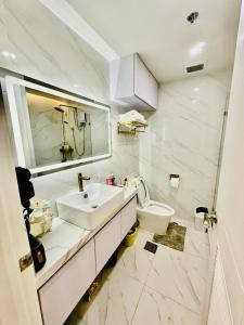 a white bathroom with a sink and a toilet at Gina Staycation The Atherton DMCI Parañaque in Manila