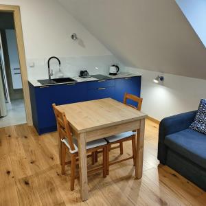 a kitchen and dining room with a table and a sink at APARTAMENTY BAŁTYCKA 4d in Rowy +11 photos