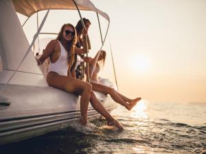 grupa ludzi siedzących na łodzi w wodzie w obiekcie VACATION MARBELLA I Brand New Terrazas de Banús Apt, 24-7 Security, a minute from the Marina, The Sea and Luxury Shopping w Marbelli