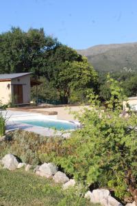 a swimming pool in a yard with a house at Lo de Almada Cabañas&Suites in Huerta Grande