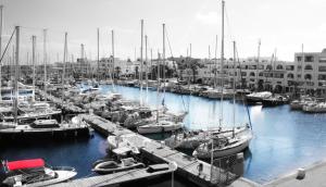 a group of boats docked in a marina with buildings at Marina Cap Monastir- Appart'Hôtel in Monastir
