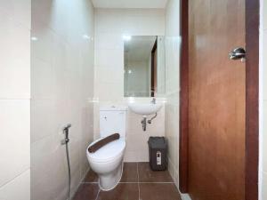 a bathroom with a toilet and a sink at Scenic Studio Room Apartment Vida View Makassar By Travelio in Pampang