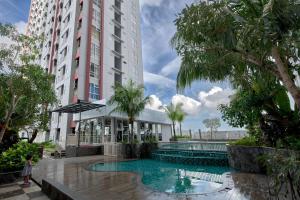 a hotel with a swimming pool in front of a building at Scenic Studio Room Apartment Vida View Makassar By Travelio in Pampang +8 photos