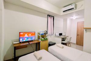 Un televizor și/sau centru de divertisment la Modern Studio (No Kitchen) at Bandaraya - Tallasa City Makassar Apartment By Travelio