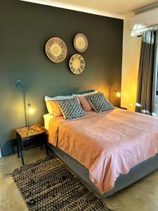 a bedroom with a bed with three plates on the wall at Kruger Willows in Marloth Park