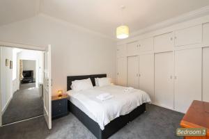 a bedroom with a large bed with white cabinets at Beach Court in North Berwick