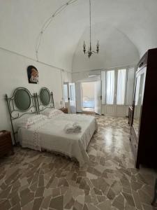 a bedroom with a large bed and a chandelier at Nonna Gio' in Martina Franca