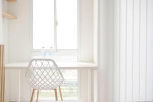 a chair sitting in front of a window at Homey and Good Choice Studio Tokyo Riverside PIK 2 Apartment By Travelio in Rawalembang