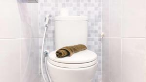 a bathroom with a toilet with a towel on it at Homey and Good Choice Studio Tokyo Riverside PIK 2 Apartment By Travelio in Rawalembang +10 photos