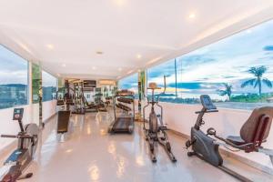 a gym with cardio equipment in a room with windows at 2 BRs Flat near Fishermans Village in Bophut 