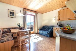 a kitchen and living room with a table and a couch at Kreuzerhof in Siusi +17 photos