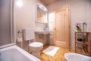 a bathroom with a toilet and a sink and a tub at Kreuzerhof in Siusi