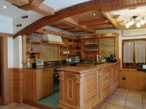 Eine Küche mit Holzschränken und einer großen Kochinsel in der Unterkunft Locanda Castil in Arco