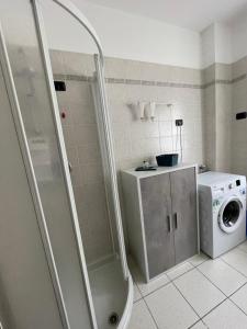 a bathroom with a shower and a washing machine at Casa Valentina in Ledro
