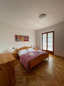 a bedroom with a large bed and a wooden floor at Casa Valentina in Ledro