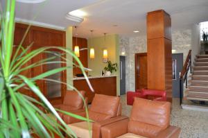 a waiting room with leather chairs and stairs at Hotel Sant Jordi in Tarragona