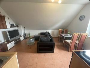 a living room with a couch and a tv at Ferienwohnung Hartung in Hinte