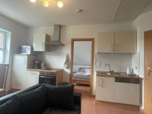 a living room with a couch and a kitchen with a counter at Ferienwohnung Hartung in Hinte +6 photos