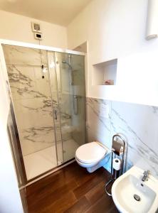 a bathroom with a shower and a toilet and a sink at Albergo Del Sole in Porto Valtravaglia