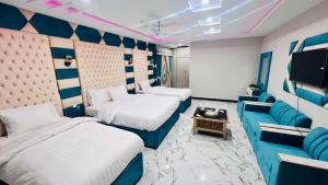 锡卡都Nestopia Hotel - Skardu的一间有两张床和一台电视的酒店房间