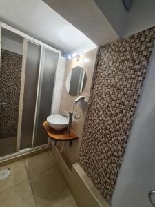 łazienka z umywalką i lustrem w obiekcie Aithra -cosy studio in centre of Poros w Poros +9 zdjęć