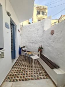 patio ze stołem i krzesłami na ścianie w obiekcie Aithra -cosy studio in centre of Poros w Poros