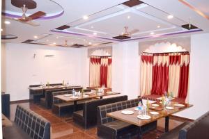 a restaurant with tables and chairs and red curtains at RUDRAKSH HOTEL & RESTAURANT in Kumbhalgarh in Kumbhalgarh