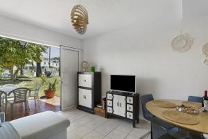 a kitchen and dining room with a table and a television at Precioso Bungalow De Playa in Maspalomas