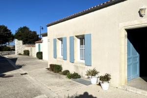 サン・マルタン・ド・レにあるIlattes entre port et plageの青い鎧戸と鉢植えの白い建物 +4枚の写真