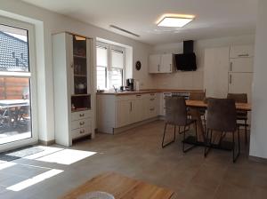 Una cocina con una mesa y sillas en una habitación. en Ferienhaus Ebsen HH 1, en Steinberg