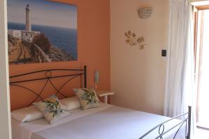 ein Schlafzimmer mit einem Bett mit einem Bild an der Wand in der Unterkunft Masseria San Cosimo in Carpignano Salentino + 70 Fotos