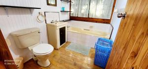 a bathroom with a toilet and a sink and a tub at Milkwood Lodge 11 - Sleeps 4 in Port Edward +6 photos