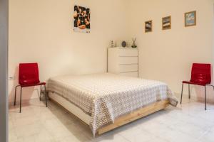 a bedroom with a bed and two red chairs at Casa Frida in Roccagloriosa