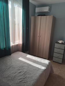 a bedroom with a bed and a dresser and a window at E L A in K'obulet'i